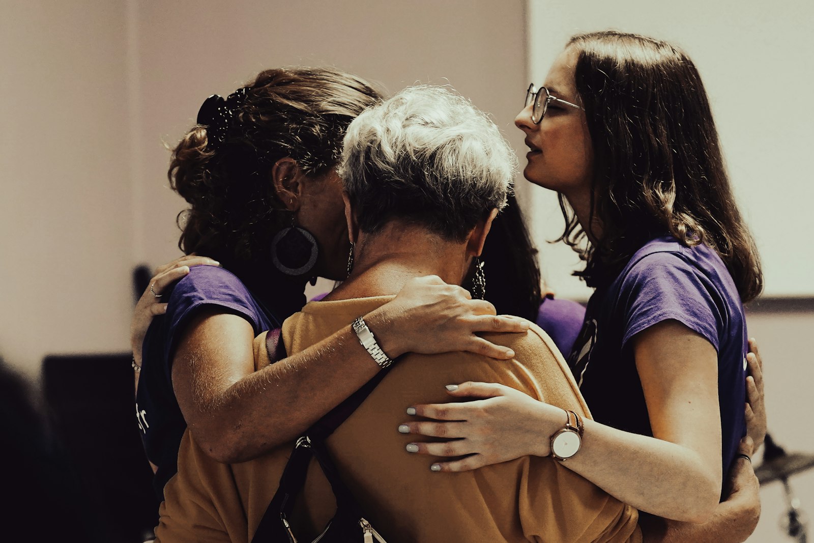 Three women sharing a warm group hug